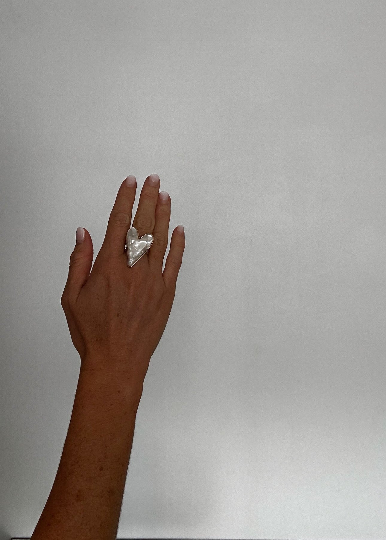 Bague dorée ajustable avec deux cœurs en résine nacrée.