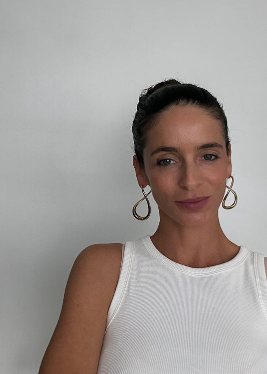 Boucles d’oreilles dorées en acier inoxydable en forme abstraite, avec fermoir puce, au design moderne et lumineux.