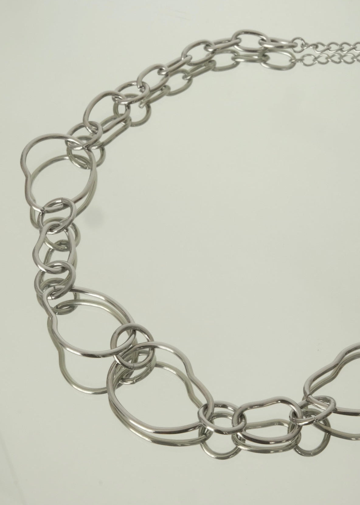 Collier argenté en acier inoxydable à grosses mailles ajourées, style moderne et élégant.