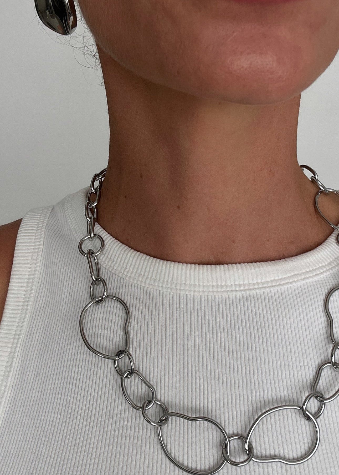 Collier argenté en acier inoxydable à grosses mailles ajourées, style moderne et élégant.
