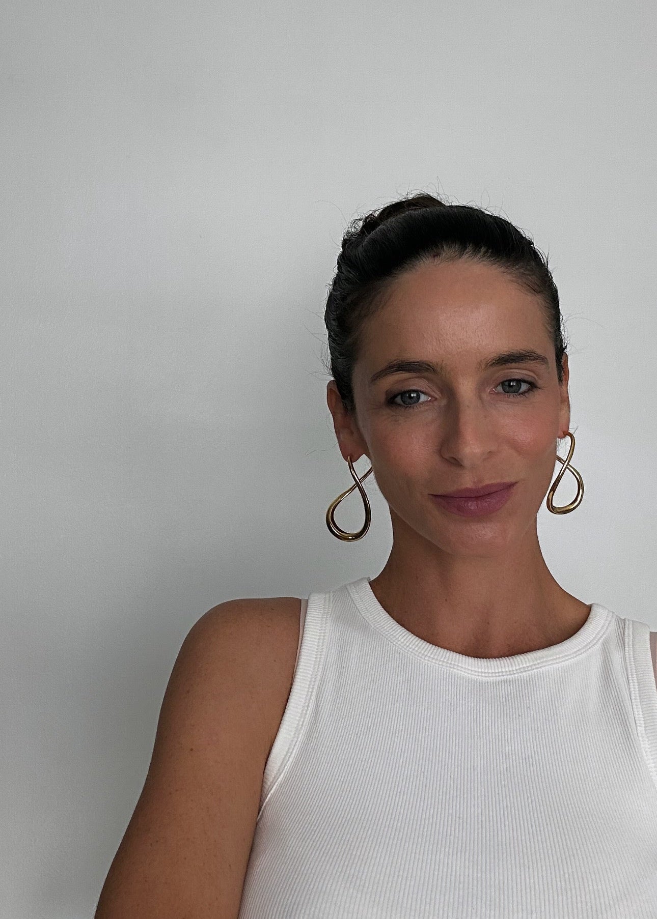 Boucles d’oreilles dorées en acier inoxydable en forme abstraite, avec fermoir puce, au design moderne et lumineux.