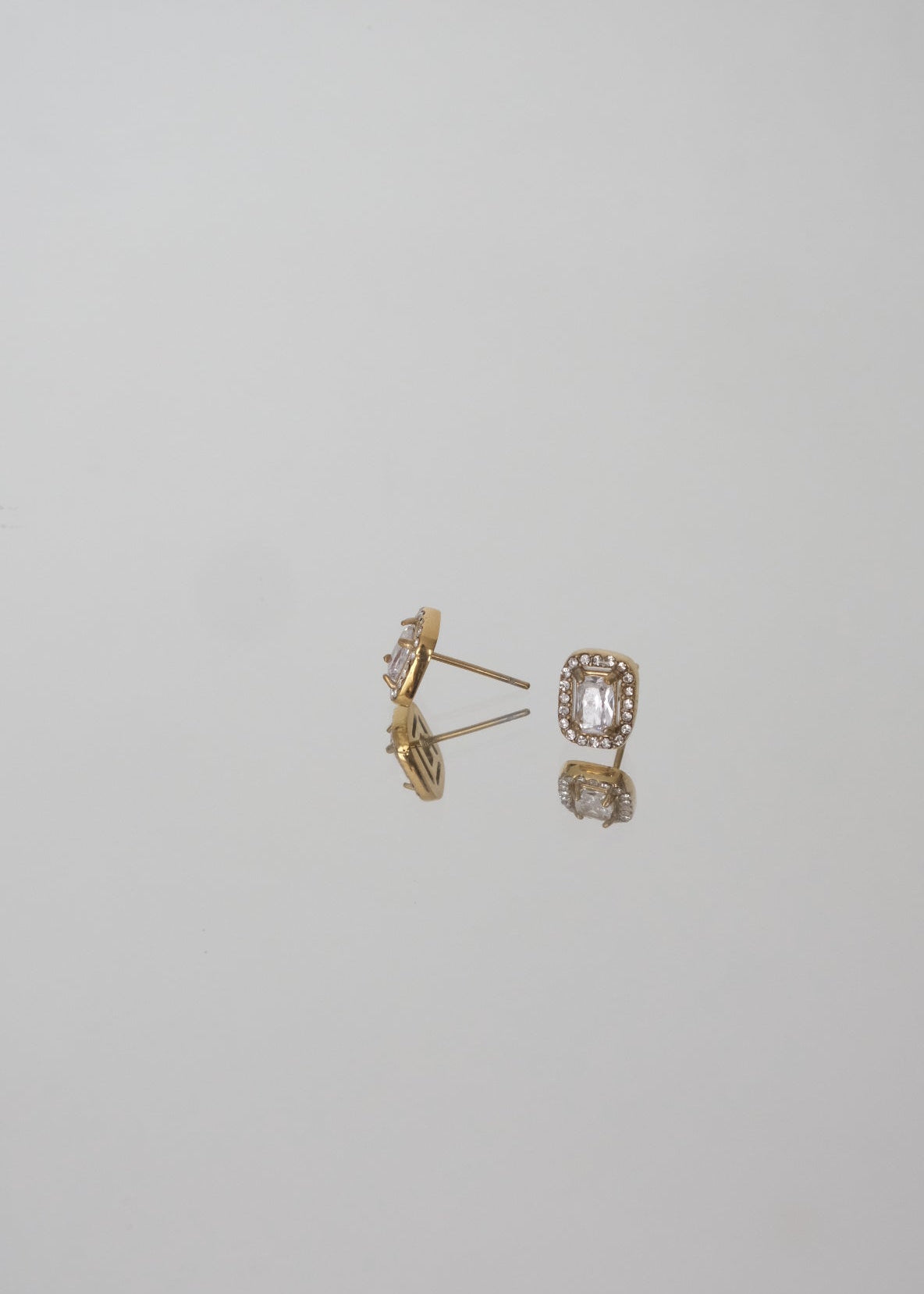 Boucles d’oreilles dorées en acier inoxydable ornées de petits strass, avec fermoir puce, au design fin et lumineux.