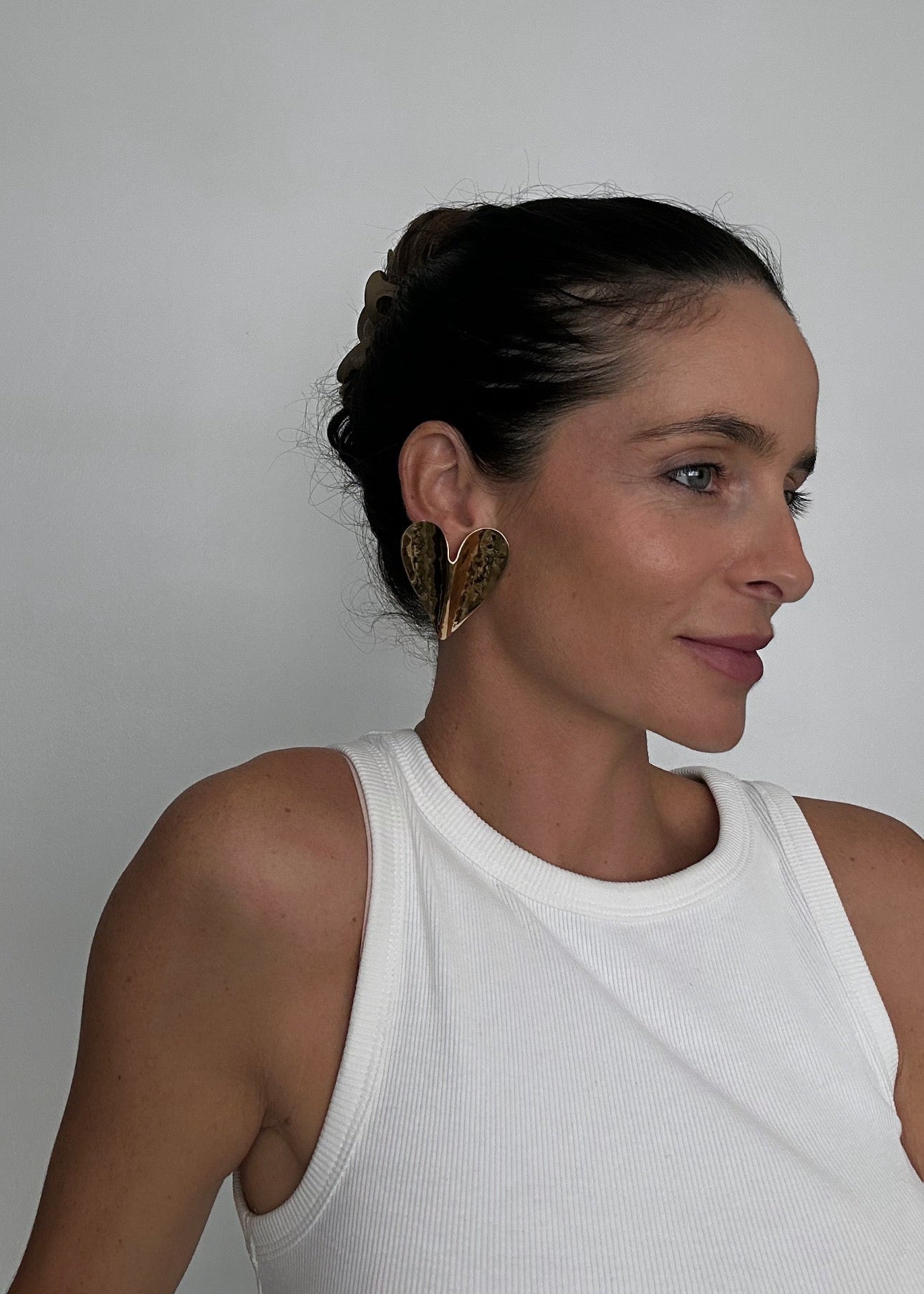 Boucles d’oreilles dorées en acier inoxydable en forme de cœur, finition effet martelé, avec fermoir puce.