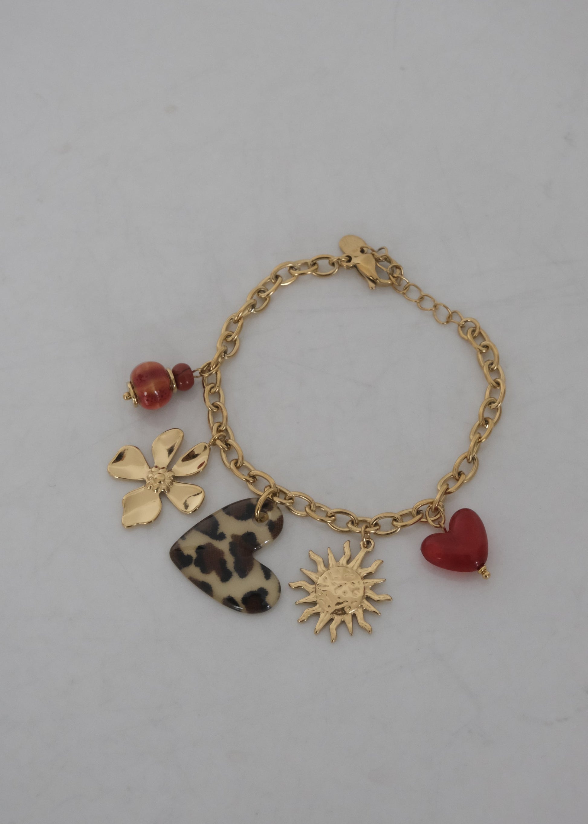 Bracelet breloque en acier inoxydable avec charms cœur léopard, soleil, cœur, fleur et perle. Bijou résistant à l’eau, féminin et intemporel.