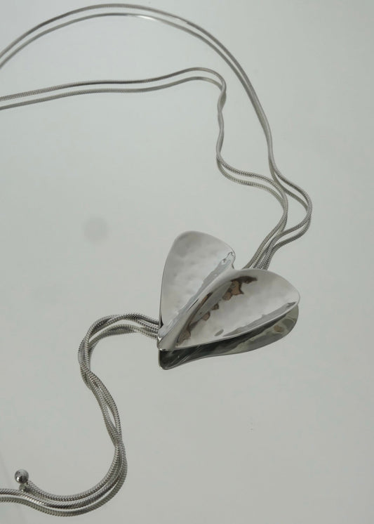 Collier cravate argenté en acier inoxydable avec pendentif cœur, au design fin, élégant et moderne.