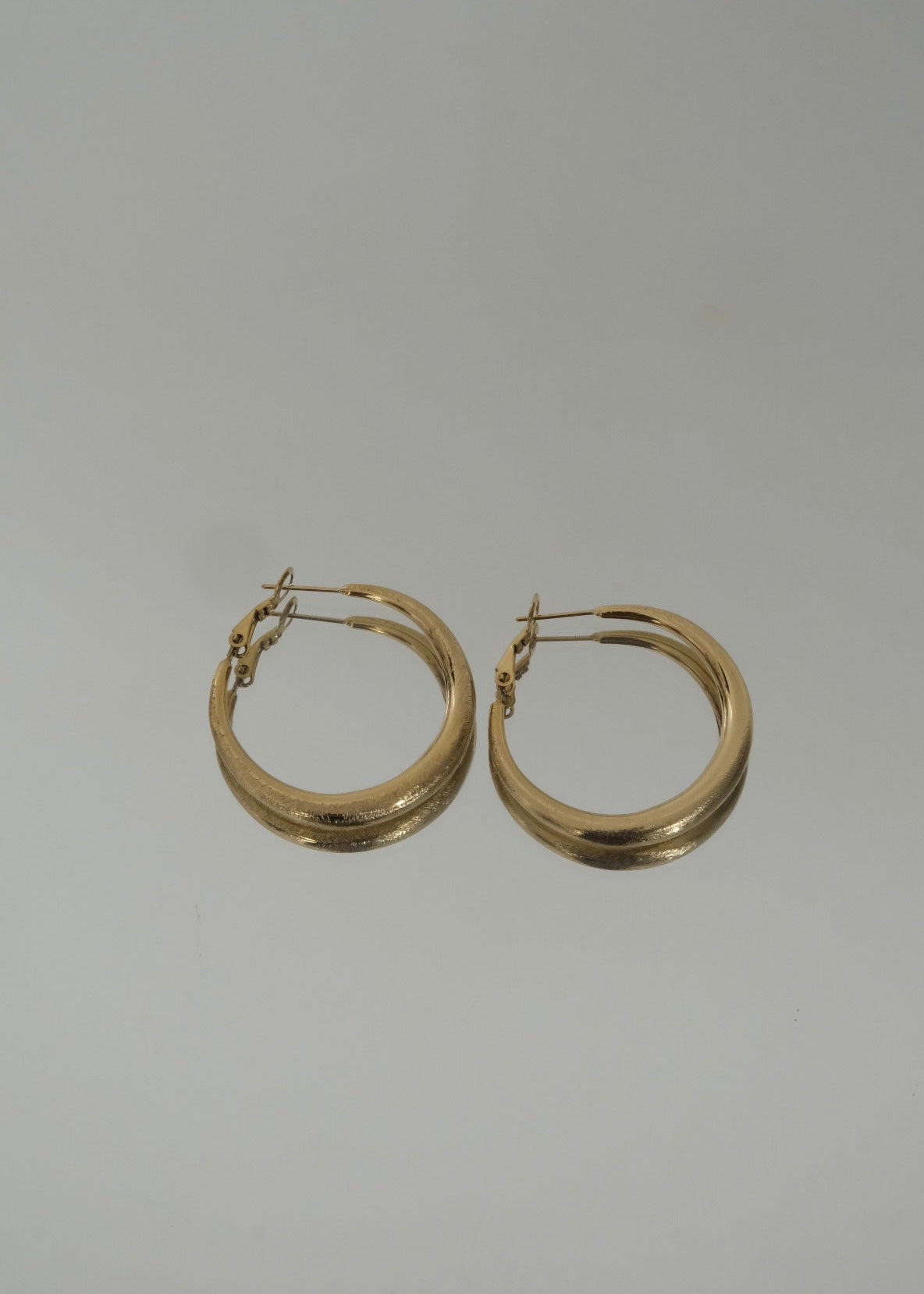 Créoles dorées en acier inoxydable, boucles d’oreilles rondes au design épuré et finition brillante.